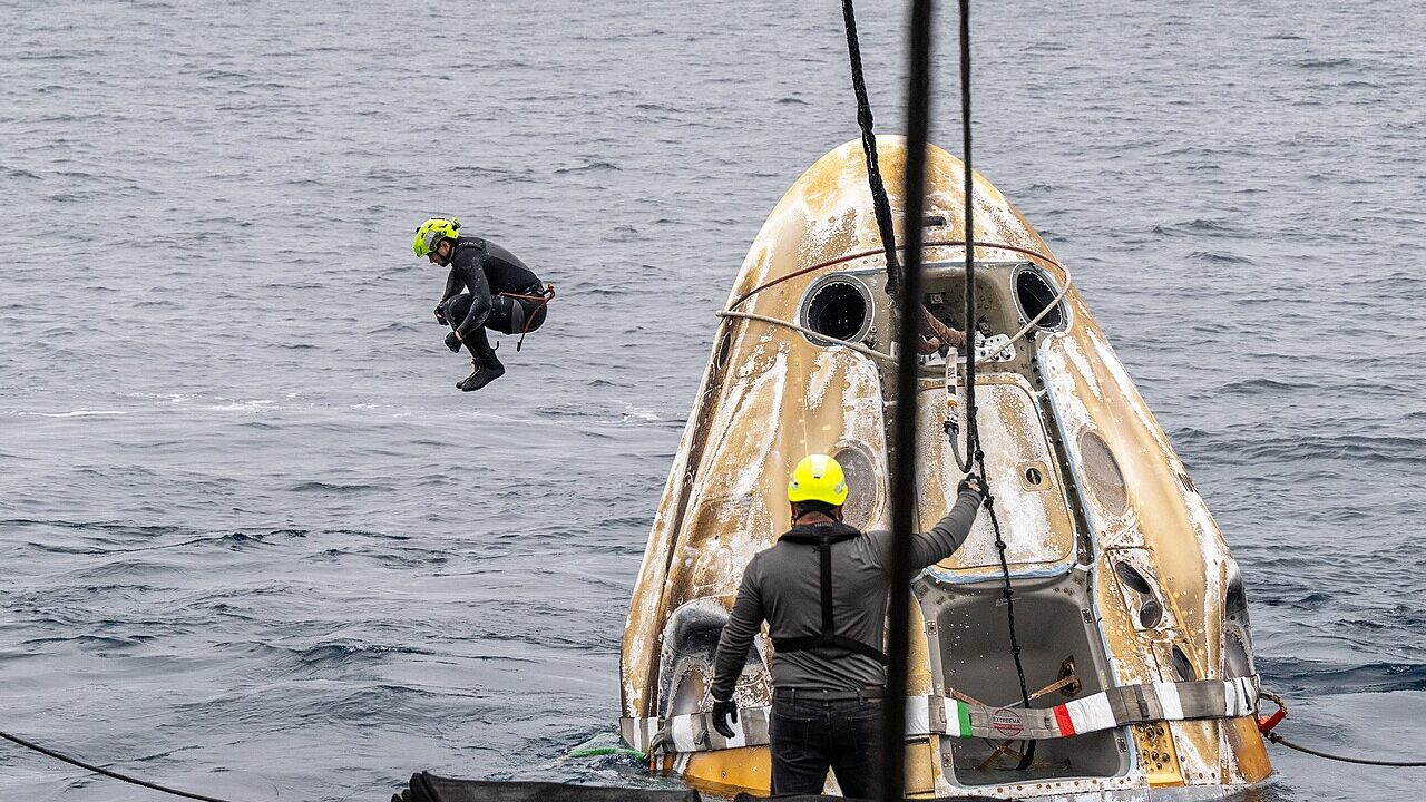 Support teams work around a Crew Dragon capsule shortly after splashdown. Photo: NASA / Keegan Barber, public domain, via Wikimedia Commons.